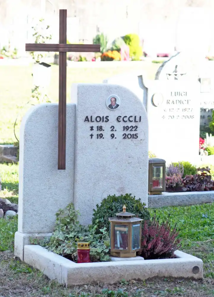 Einzelgrabstein aus hellem Marmor mit Kupferkreuz