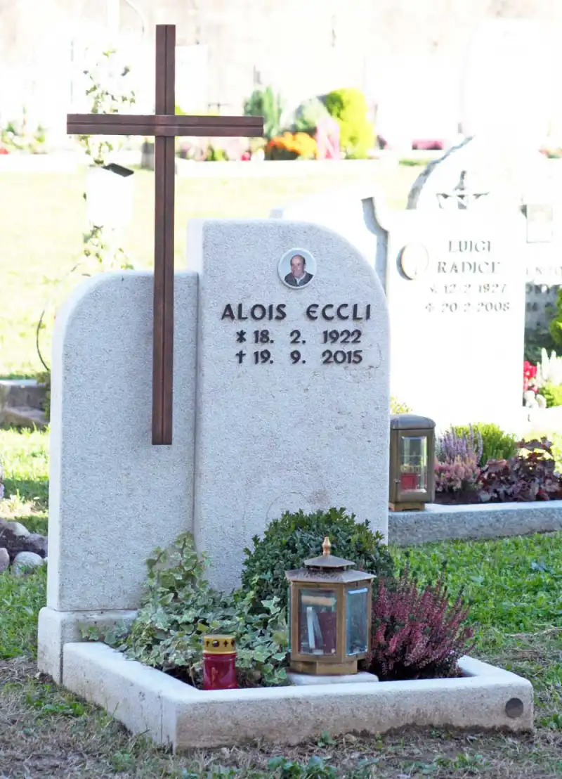 Einzelgrabstein aus hellem Marmor mit Kupferkreuz