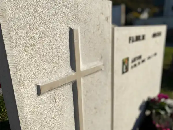 Lapide con croce e scritta con lettere in bronzo