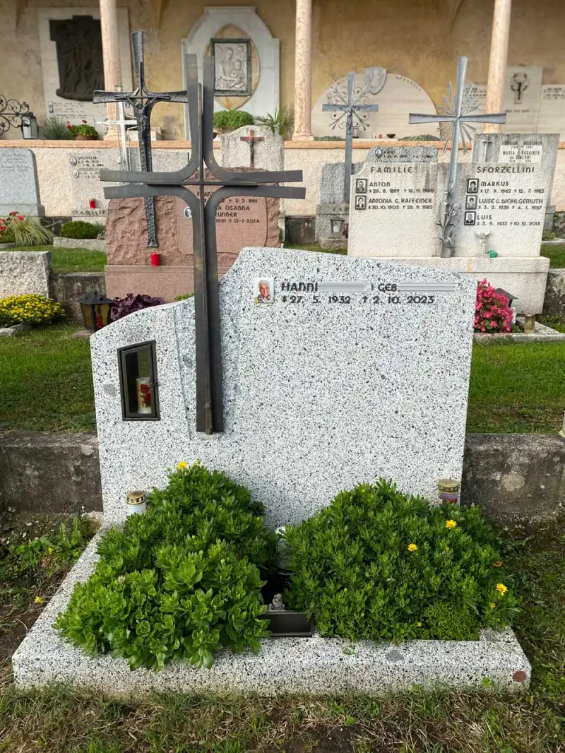 Moderner Grabstein aus weiß/schwarzem Granit mit integrierter Laterne und Kreuz
