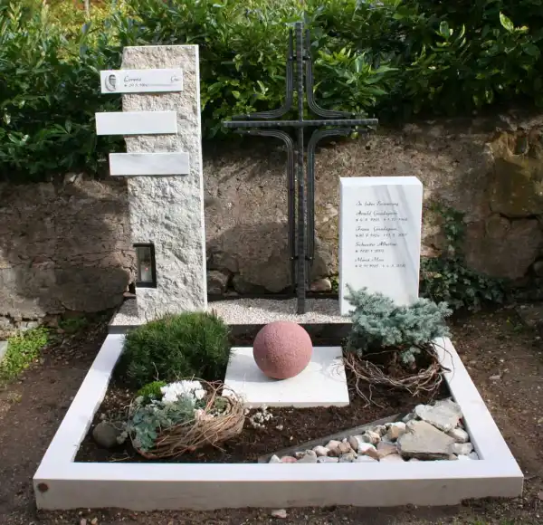 Moderne Grabgestaltung mit Steinstehlen und linearem Schmiedeeisenkreuz
