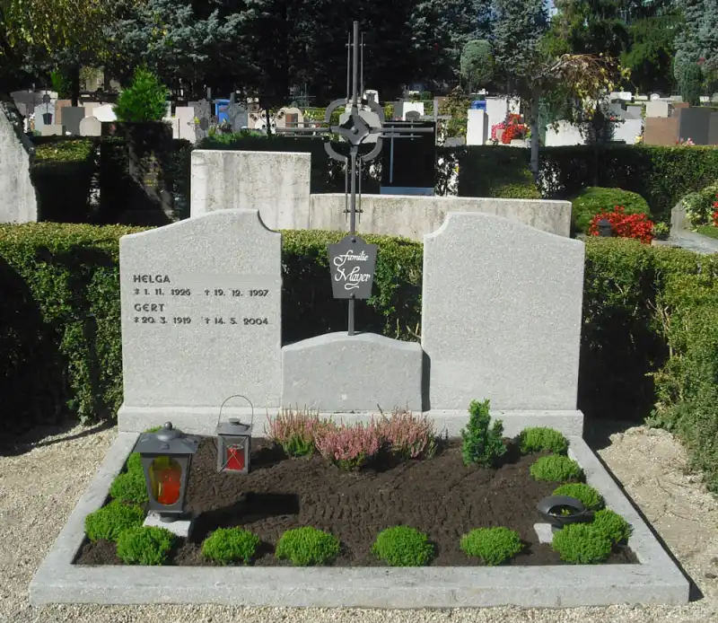 Klassischer Grabstein aus grauem Porphyr mit Schmiedeeisenkreuz