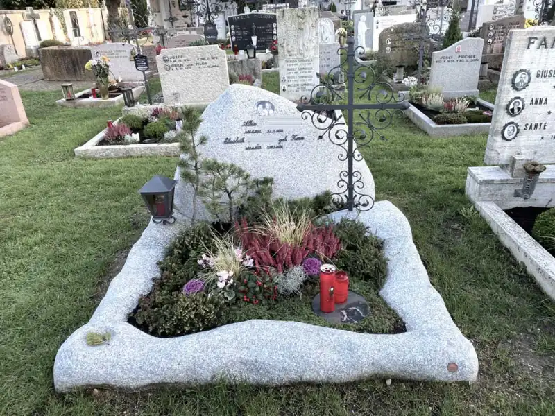 Familiengrab aus einem Granitfindling mit kleinem Kreuz