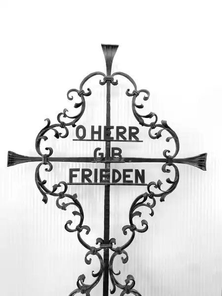Die Inschrift „O HERR GIB FRIEDEN“ vermittelt eine zeitlose Hoffnung, die über Generationen hinweg Bestand hat