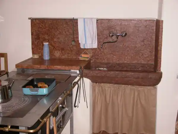 Lavello da cucina rustico con paraspruzzi realizzato in marmo rosso